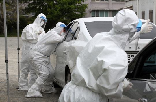 지난 16일 전남 담양 종합체육관에 설치된 드라이브 스루 임시선별진료소에서 의료진이 신종 코로나바이러스 감염증(코로나19) 검체 채취를 하고 있다. 연합뉴스